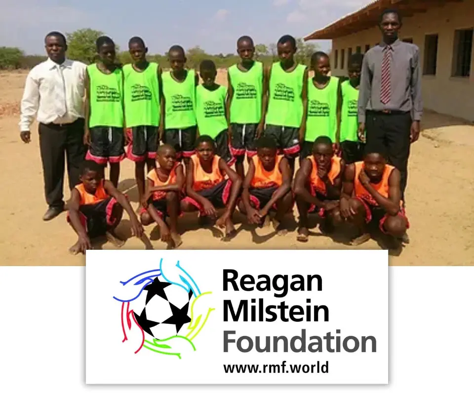 Young players in bibs holding footballs with the Reagan Milstein Foundation